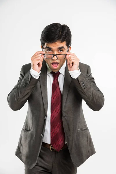 Empresario indio quitando o sosteniendo anteojos y mirando a la cámara sorprendida con la boca abierta, aislado sobre fondo blanco — Foto de Stock