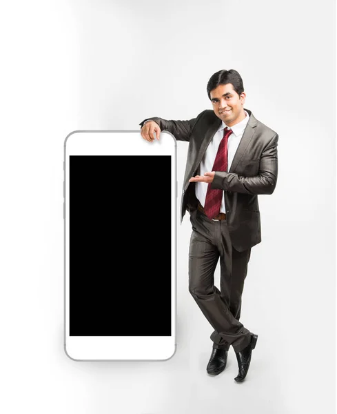Concepto de foto de un hombre de negocios indio o asiático descansando mano sobre un gran teléfono inteligente y en la presentación de pose, aislado sobre fondo blanco — Foto de Stock