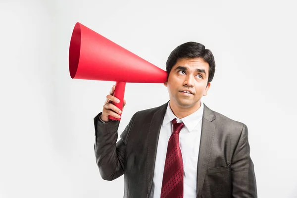 Índio homem de negócios ouvir um anúncio ou fofoca através de alto-falante vermelho ou mega microfone feito de papel, isolado sobre fundo branco — Fotografia de Stock