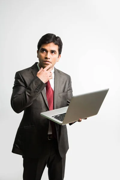 Retrato del joven empresario indio confiado que trabaja en su computadora o portátil en la oficina, Empresario que usa una computadora portátil y sonríe de pie aislado sobre un fondo blanco — Foto de Stock