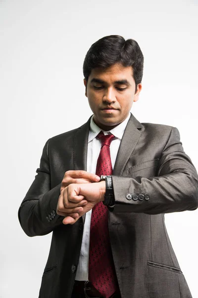 Zaman para kavramı - Hint genç işadamı arıyor / beyaz arka plan üzerinde izole saat ayakta kol saati içinde ayarlama — Stok fotoğraf