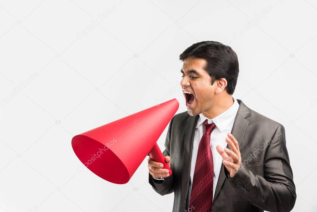 indian male businessman announcing or spreading news using red speaker or mega mic made up of paper, isolated over white background