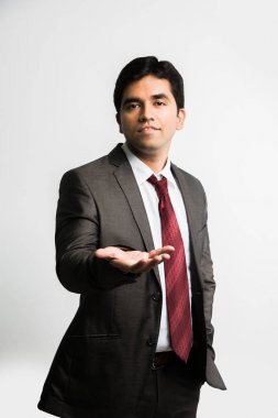 Hintli genç işadamı üzerine yazmak bir şey Dengeleme yaparken kameraya bakarak tam pic yukarı bakacak şekilde palmiye ve takım elbise ve kravat, gibi tam kurumsal kıyafetleri giyen beyaz arka plan üzerinde izole