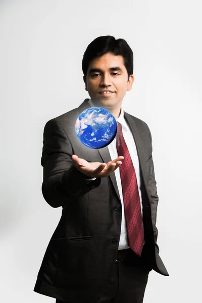 Indisk ung affärsman tittar på en flytande blå globe eller jorden modell över höger handflata iklädd komplett corporate klänning eller klädsel som kostym och slips, isolerade över vit bakgrund — Stockfoto