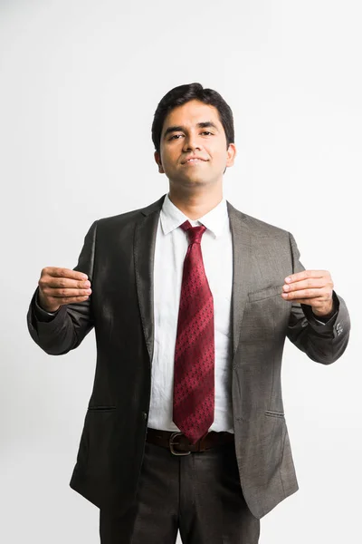 Fulla pic av indisk ung affärsman tittar kameran medan poserar som att hålla något i båda händerna samtidigt bär komplett corporate klädsel som kostym och slips, isolerade över vit bakgrund — Stockfoto