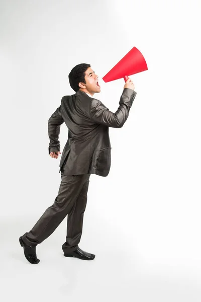 Homem indiano empresário anunciando ou divulgando notícias usando alto-falante vermelho ou mega microfone feito de papel, isolado sobre fundo branco — Fotografia de Stock