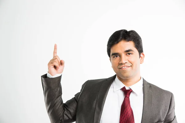 Fulla pic av indisk ung affärsman tittar kameran samtidigt balansera något på pekfingret och bär komplett corporate klädsel som kostym och slips, isolerade över vit bakgrund — Stockfoto