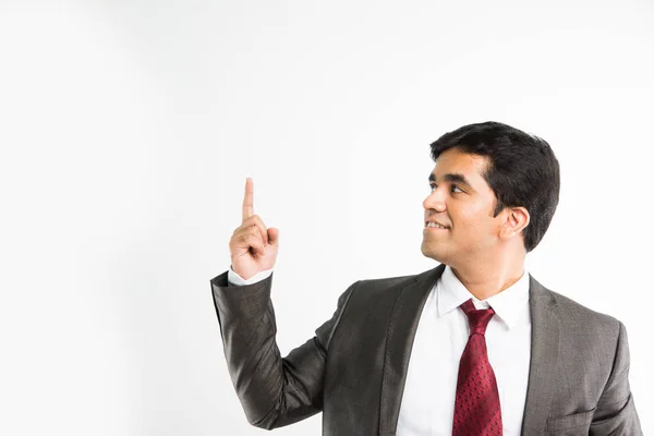 Fulla pic av indisk ung affärsman tittar kameran samtidigt balansera något på pekfingret och bär komplett corporate klädsel som kostym och slips, isolerade över vit bakgrund — Stockfoto