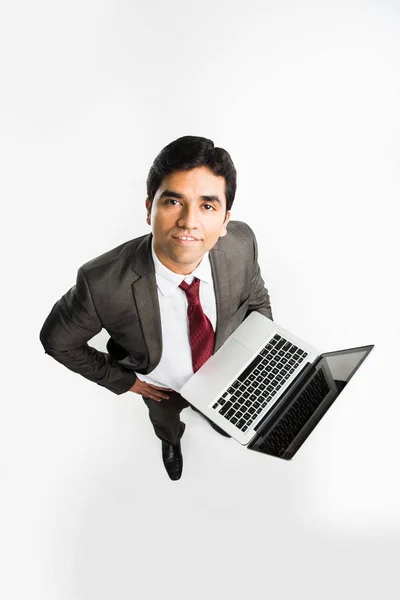 Empresário indiano segurando laptop sobre fundo branco e olhando para cima em direção à câmera, uma visão do topo também conhecido como visão de olho de pássaro — Fotografia de Stock