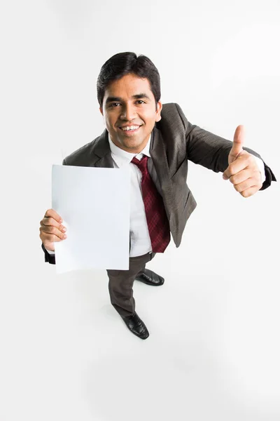 Indisk ung affärsman hålla ett tomt vitt papper och visar framgång tecken eller tummen upp, ett fågelperspektiv från översta visar perspektivvy av man — Stockfoto