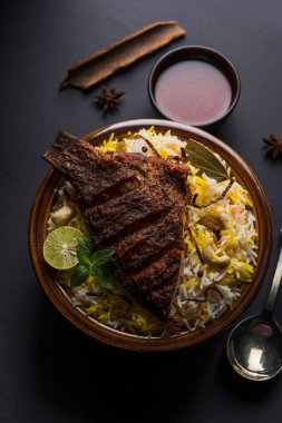 Biryani balık ya da balık pirinç - popüler Hint vejetaryen Sigara tarifi balık yapılan taze otlar Hint baharatlarla Marine ve pişmiş ile Basmati pirinç, seçici odak