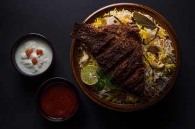 Biryani balık ya da balık pirinç - popüler Hint vejetaryen Sigara tarifi balık yapılan taze otlar Hint baharatlarla Marine ve pişmiş ile Basmati pirinç, seçici odak