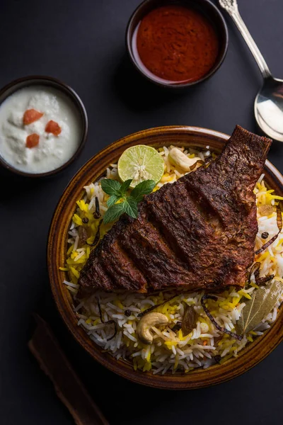 Peixe Biryani ou peixe Arroz - Receita indiana não vegetariana popular feita de peixe marinado com especiarias indianas ervas frescas e cozido com arroz Basmati, foco seletivo — Fotografia de Stock