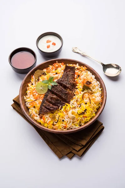 Biryani balık ya da balık pirinç - popüler Hint vejetaryen Sigara tarifi balık yapılan taze otlar Hint baharatlarla Marine ve pişmiş ile Basmati pirinç, seçici odak