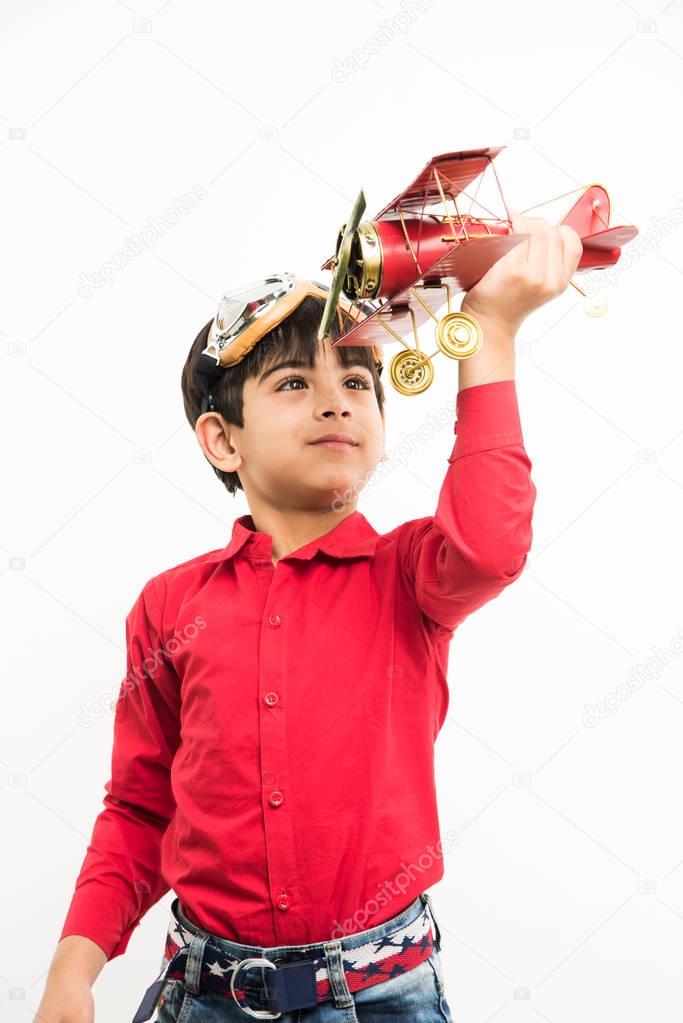 indian cute kid or boy with toy plane over white background