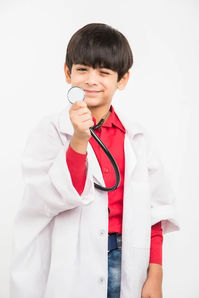 Indiana bonito menino ou criança no médico uniforme com estetoscópio e porquinho banco na mão — Fotografia de Stock
