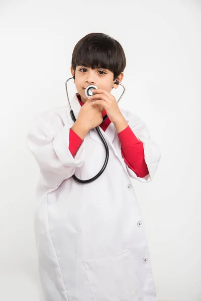 Indio lindo niño o niño en uniforme de médico con estetoscopio y alcancía en la mano — Foto de Stock