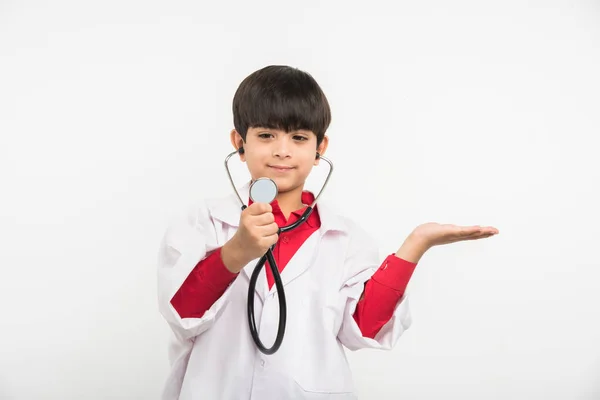 Indien mignon garçon ou enfant en uniforme de médecin avec stéthoscope et tirelire à la main — Photo