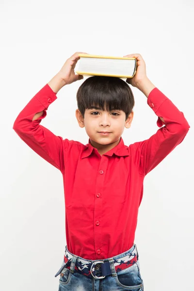 Αγόρι που κατέχουν πάνω από το κεφάλι, βιβλίο ή ινδική χαριτωμένο παιδί απομονωθεί σε λευκό φόντο — Φωτογραφία Αρχείου