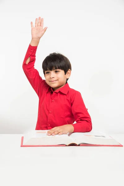 Ινδική χαριτωμένο μικρό αγόρι ή παιδί ανάγνωση βιβλίο πέρα από μελέτη του πίνακα, απομονώνονται σε λευκό φόντο — Φωτογραφία Αρχείου