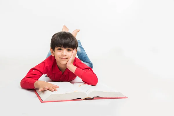 Cute Little Indian Boy Reading Book While Sitting Lying White — Stock Photo, Image