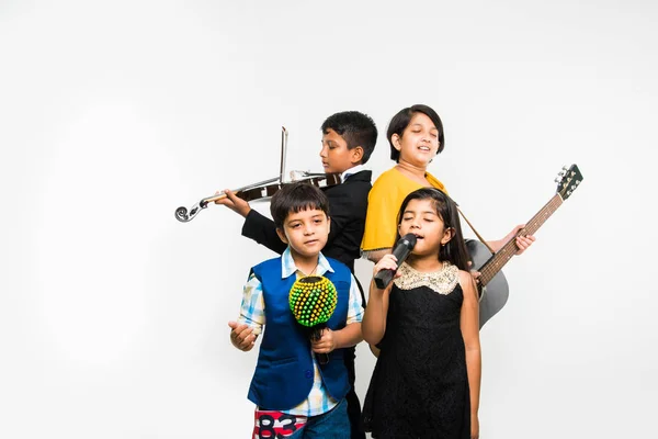 indian kids performing and singing while playing guitar, violin, flute, minor musical instrument etc in a band, isolated over white background