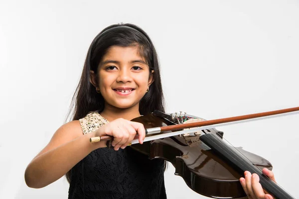 indian girl learning to play playing violin, isolated over white background