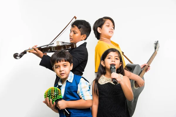 Niños indios tocando y cantando mientras tocan guitarra, violín, flauta, instrumento musical menor, etc en una banda, aislados sobre fondo blanco — Foto de Stock