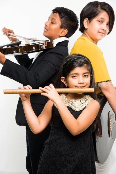 Bambini indiani che si esibiscono e cantano mentre suonano chitarra, violino, flauto, strumento musicale minore ecc in una band, isolato su sfondo bianco — Foto Stock
