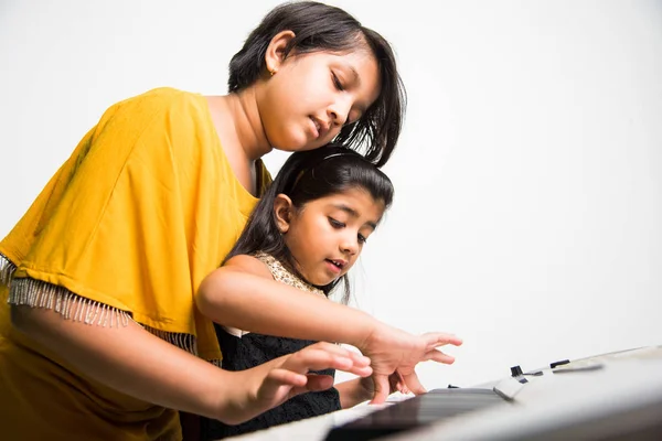 可爱小印度女孩弹钢琴或键盘，一种乐器 — 图库照片