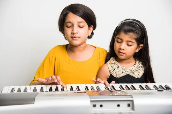 可爱小印度女孩弹钢琴或键盘，一种乐器 — 图库照片
