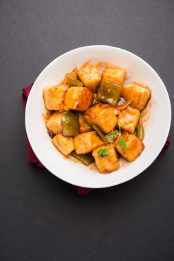 Baharatlı Paneer veya kuru biber paneer veya paneer tikka veya süzme peynir, kırmızı biber ve soğan, favori Hint başlangıç menüsü, seçici odak ile beyaz yemek servis