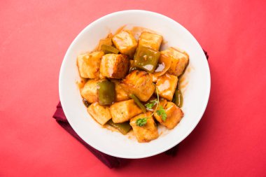 Baharatlı Paneer veya kuru biber paneer veya paneer tikka veya süzme peynir, kırmızı biber ve soğan, favori Hint başlangıç menüsü, seçici odak ile beyaz yemek servis