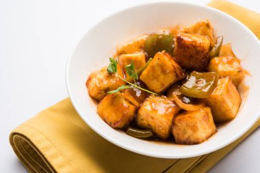 Baharatlı Paneer veya kuru biber paneer veya paneer tikka veya süzme peynir, kırmızı biber ve soğan, favori Hint başlangıç menüsü, seçici odak ile beyaz yemek servis