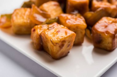 Baharatlı Paneer veya kuru biber paneer veya paneer tikka veya süzme peynir, kırmızı biber ve soğan, favori Hint başlangıç menüsü, seçici odak ile beyaz yemek servis