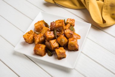 Baharatlı Paneer veya kuru biber paneer veya paneer tikka veya süzme peynir, kırmızı biber ve soğan, favori Hint başlangıç menüsü, seçici odak ile beyaz yemek servis