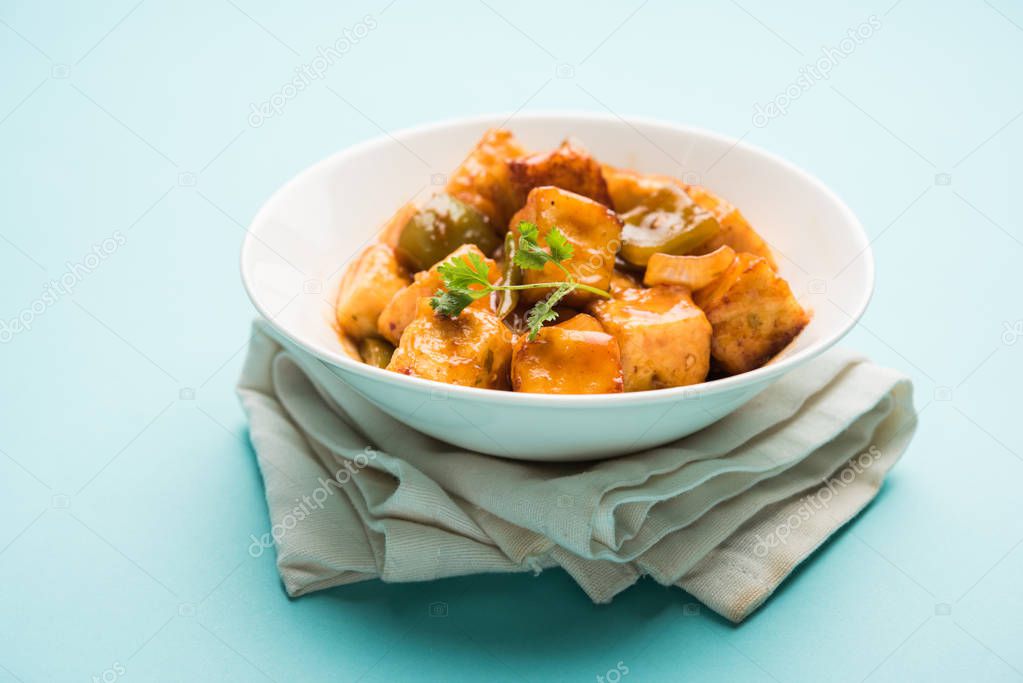 Spicy Paneer or dry chilli paneer or paneer tikka or cottage cheese, served in white Dish with capsicum and onion, favourite indian starter menu, selective focus