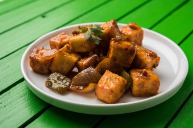 Baharatlı Paneer veya kuru biber paneer veya paneer tikka veya süzme peynir, kırmızı biber ve soğan, favori Hint başlangıç menüsü, seçici odak ile beyaz yemek servis