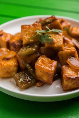 Baharatlı Paneer veya kuru biber paneer veya paneer tikka veya süzme peynir, kırmızı biber ve soğan, favori Hint başlangıç menüsü, seçici odak ile beyaz yemek servis