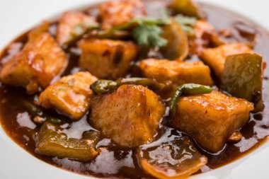 Baharatlı Paneer veya kuru biber paneer veya paneer tikka veya süzme peynir, kırmızı biber ve soğan, favori Hint başlangıç menüsü, seçici odak ile beyaz yemek servis