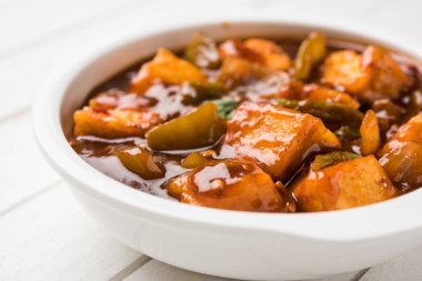 Baharatlı Paneer veya kuru biber paneer veya paneer tikka veya süzme peynir, kırmızı biber ve soğan, favori Hint başlangıç menüsü, seçici odak ile beyaz yemek servis