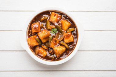 Baharatlı Paneer veya kuru biber paneer veya paneer tikka veya süzme peynir, kırmızı biber ve soğan, favori Hint başlangıç menüsü, seçici odak ile beyaz yemek servis