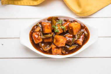 Baharatlı Paneer veya kuru biber paneer veya paneer tikka veya süzme peynir, kırmızı biber ve soğan, favori Hint başlangıç menüsü, seçici odak ile beyaz yemek servis