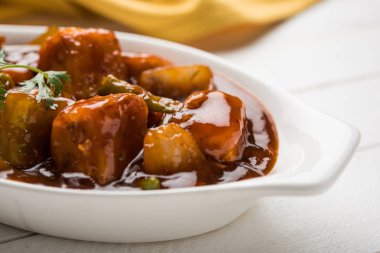 Baharatlı Paneer veya kuru biber paneer veya paneer tikka veya süzme peynir, kırmızı biber ve soğan, favori Hint başlangıç menüsü, seçici odak ile beyaz yemek servis