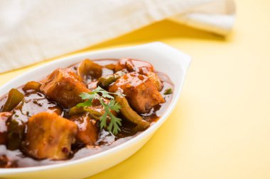 Baharatlı Paneer veya kuru biber paneer veya paneer tikka veya süzme peynir, kırmızı biber ve soğan, favori Hint başlangıç menüsü, seçici odak ile beyaz yemek servis
