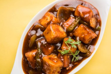 Baharatlı Paneer veya kuru biber paneer veya paneer tikka veya süzme peynir, kırmızı biber ve soğan, favori Hint başlangıç menüsü, seçici odak ile beyaz yemek servis