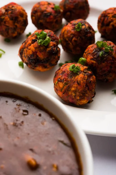 Gobi or veg Manchurian dry or with gravy - Popular street food of India made of cauliflower florets, selective focus