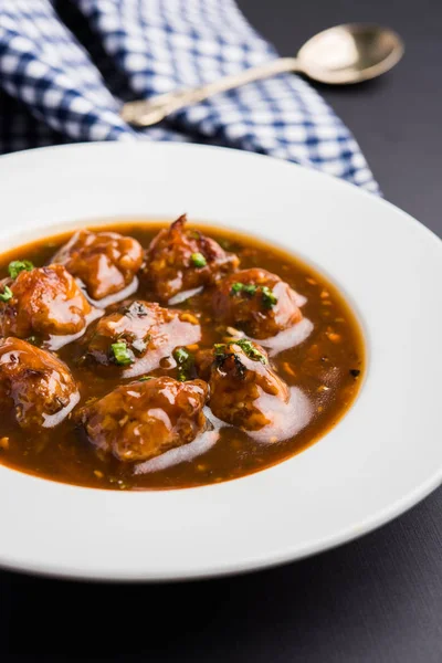 Gobi or veg Manchurian dry or with gravy - Popular street food of India made of cauliflower florets, selective focus