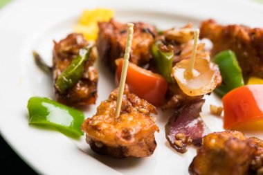 Baharatlı Paneer veya kuru biber paneer veya paneer tikka veya süzme peynir, kırmızı biber ve soğan, favori Hint başlangıç menüsü, seçici odak ile beyaz yemek servis