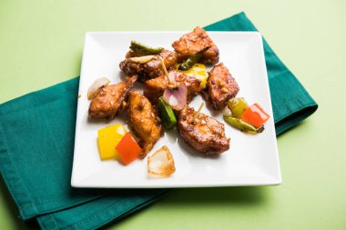 Baharatlı Paneer veya kuru biber paneer veya paneer tikka veya süzme peynir, kırmızı biber ve soğan, favori Hint başlangıç menüsü, seçici odak ile beyaz yemek servis